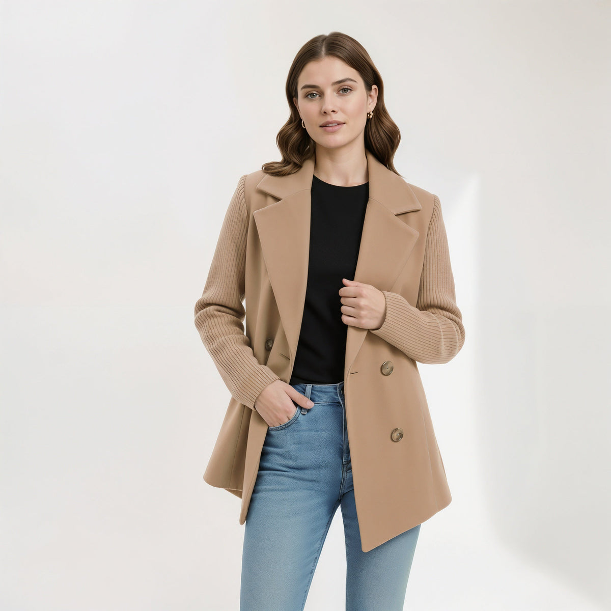 Woman wearing a camel blazer coat over a black top and jeans