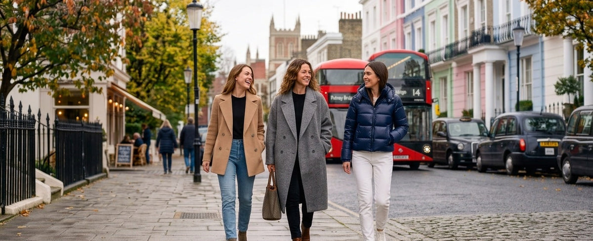 Three women walking down a city street in coats and knitwear